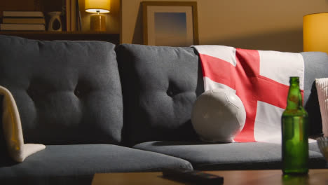 Sofa-In-Lounge-With-English-Flag-And-Ball-As-Fans-Prepare-To-Watch-Football-Soccer-Match-On-TV