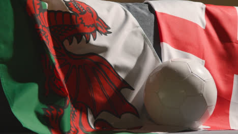 Sofa-In-Lounge-With-English-And-Welsh-Flags-And-Ball-As-Fans-Watch-Football-Soccer-Match-On-TV-1