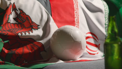 Sofa-In-Lounge-With-Welsh-And-Iranian-Flags-And-Ball-As-Fans-Prepare-To-Watch-Football-Soccer-Match-On-TV-2