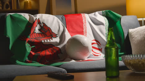 Sofa-In-Lounge-With-Welsh-And-Iranian-Flags-And-Ball-As-Fans-Prepare-To-Watch-Football-Soccer-Match-On-TV-3