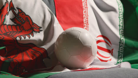 Sofa-In-Der-Lounge-Mit-Walisischer-Und-Iranischer-Flagge-Und-Ball,-Während-Sich-Die-Fans-Darauf-Vorbereiten,-Fußballspiele-Im-Fernsehen-Zu-Sehen-5