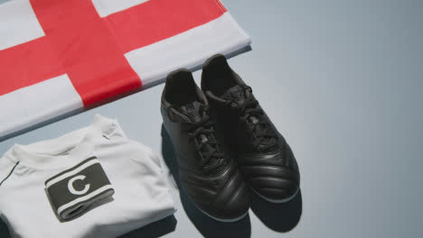 Studio-Still-Life-Shot-Of-Football-Soccer-Boots-English-Flag-Shirt-And-Shorts-And-Captains-Armband-