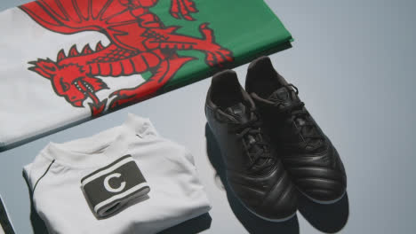Studio-Still-Life-Shot-Of-Football-Soccer-Boots-Welsh-Flag-Shirt-And-Shorts-And-Captains-Armband-