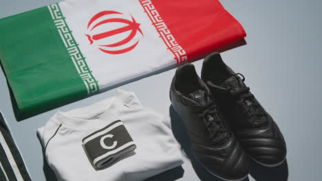 Studio-Stillleben-Schuss-Von-Fußball-Fußballschuhen-Mit-Iranischer-Flagge,-Hemd-Und-Shorts-Und-Kapitänsbinde