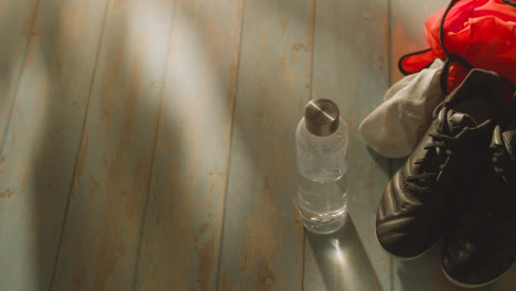 Studio-Still-Life-Shot-Of-Football-Soccer-With-Boots-Socks-And-Training-Bib-In-Dressing-Room