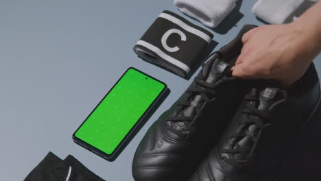 Studio-Flat-Lay-Shot-Of-Football-Soccer-Boots-Shorts-Captains-Armband-And-Mobile-Phone-1