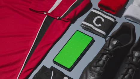 Studio-Flat-Lay-Shot-Of-Football-Soccer-Boots-Shirt-Captains-Armband-And-Mobile-Phone-4