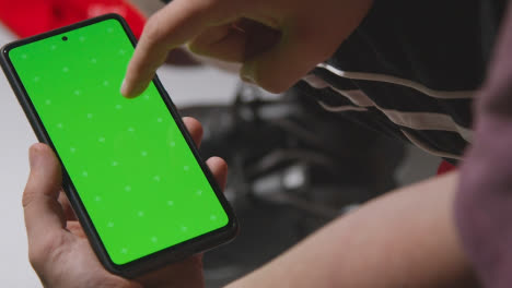 Close-Up-Of-Man-In-Dressing-Room-Ready-For-Football-Soccer-Match-Looking-At-Green-Screen-Mobile-Phone