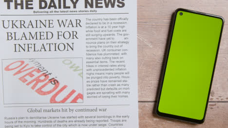Zeitung-Mit-Schlagzeile-über-Krieg-In-Der-Ukraine-Und-Inflation-Neben-Greenscreen-handy-Mit-Handscrollen