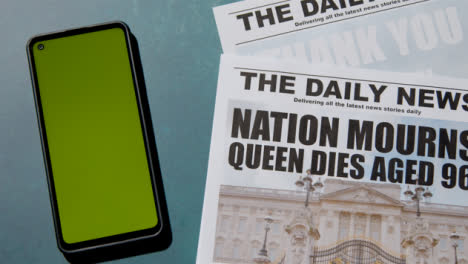 Top-View-of-Queen-Elizabeth-Death-Newspaper-Headlines-with-Green-Screen-Phone-01