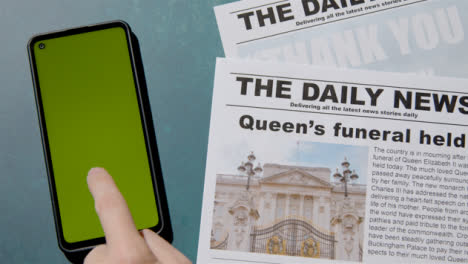 Blick-Von-Oben-Auf-Queen-Elizabeth-Death-Zeitungsschlagzeilen-Mit-Greenscreen-Telefon-04