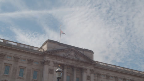 Tiro-Inclinado-De-La-Bandera-Del-Reino-Unido-Del-Palacio-De-Buckingham-Ondeando-A-Media-Asta