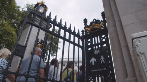 Tiro-Inclinado-Siguiendo-A-Una-Multitud-A-Través-De-La-Puerta-Cerca-Del-Palacio-De-Buckingham