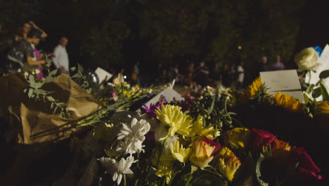 Close-Up-Shot-of-Pile-of-Floral-Tributes-and-Mourners-In-Green-Park-London