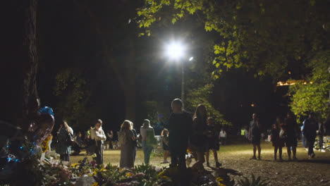 Kamerafahrt-Von-Trauernden-Und-Floralen-Ehrungen-Im-Grünen-Park-01