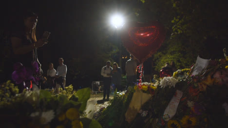 Low-Angle-Shot-of-Floral-Tributes-and-Mourners-In-London's-Green-Park