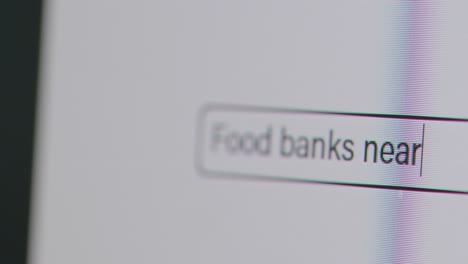Person-Typing-Food-Banks-Near-Me-Into-Computer-Search-Engine-In-Cost-Of-Living-Crisis