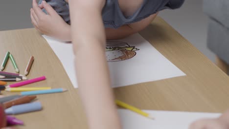 Close-Up-Of-Two-Children-At-Home-Colouring-In-Picture-At-Table-2