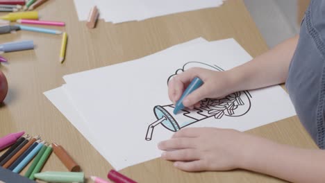 Primer-Plano-De-Un-Niño-En-Casa-Coloreando-Una-Imagen-De-Hamburguesas-Fritas-Y-Batido-En-La-Mesa