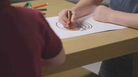 Close-Up-Of-Child-At-Home-Colouring-In-Picture-Of-Burger-At-Table-2