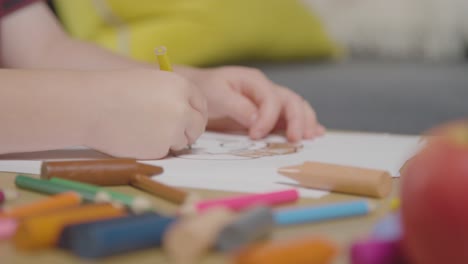 Primer-Plano-De-Un-Niño-En-Casa-Coloreando-La-Imagen-De-La-Comida-En-La-Mesa-Con-Manzana-Fresca-En-Primer-Plano