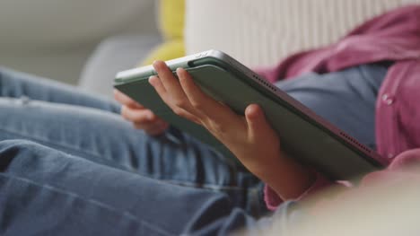 Close-Up-Of-Two-Children-Sitting-On-Sofa-At-Home-Digital-Tablet-Together-1