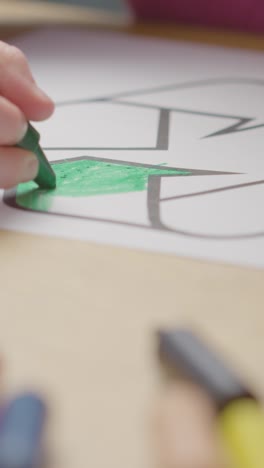 Vertical-Video-Close-Up-Of-Child-At-Home-Colouring-In-Picture-Of-Recycling-Symbol-At-Table-