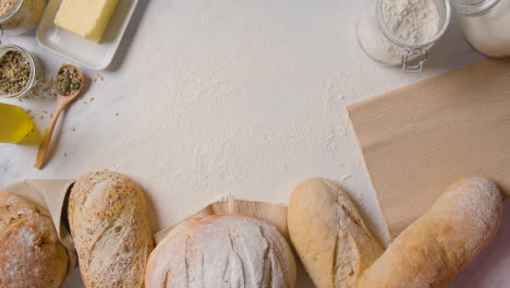 Overhead-Shot-Of-Freshly-Baked-Loaves-Of-Bread-On-Floured-Marble-Work-Surface