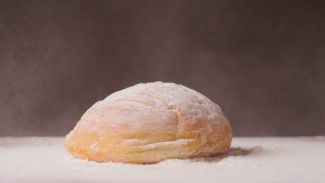 Loaf-Of-Fresh-Bread-Being-Dropped-Onto-Work-Surface-Covered-In-Flour