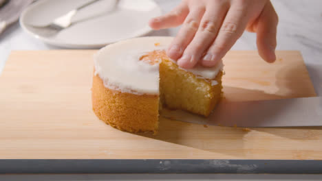 Persona-Cortando-Una-Rebanada-De-Pastel-Casero-De-Limón-En-Un-Plato-En-La-Superficie-De-Trabajo-De-La-Cocina-2