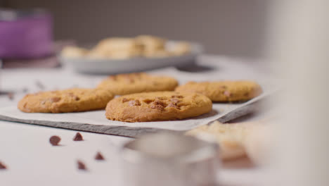 Bandeja-De-Galletas-Caseras-Con-Trocitos-De-Chocolate-En-La-Superficie-De-Trabajo-De-La-Cocina-Con-Ingredientes