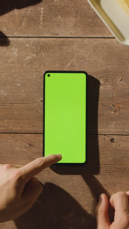 Vertical-Video-Overhead-Shot-Of-Person-Waiting-Whilst-Green-Screen-Mobile-Phone-Buffers