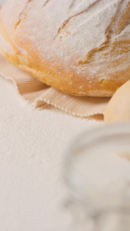 Vertical-Video-Shot-Of-Freshly-Baked-Loaves-Of-Bread-On-Work-Surface