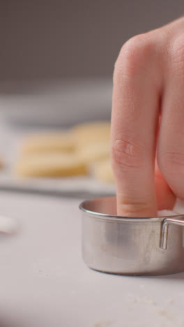 Vertikales-Video-Einer-Person,-Die-Zucker-Auf-Hausgemachte-Shortbread-Kekse-Auf-Einem-Tablett-Auf-Der-Küchenarbeitsfläche-Streut