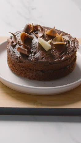 Vertical-Video-Of-Homemade-Chocolate-Cake-On-Plate-On-Kitchen-Work-Surface