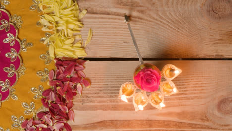 Person-Holding-Five-Wick-Lamp-On-Table-Decorated-To-Celebrate-Festival-Of-Diwali