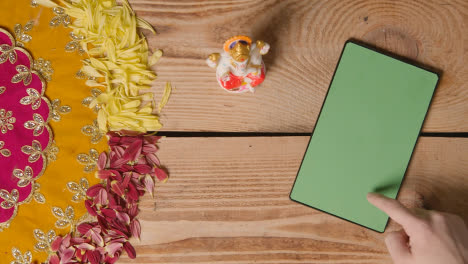 Person-Using-Green-Screen-Digital-Tablet-On-Table-Decorated-For-Festival-Of-Diwali