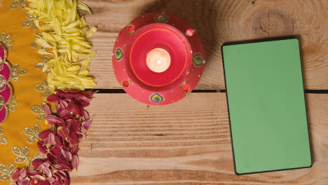 Clay-Pot-With-Lights-Being-Used-To-Celebrate-Indian-Wedding-Diwali-Or-Navratri-On-Decorated-Table-With-Digital-Tablet-2