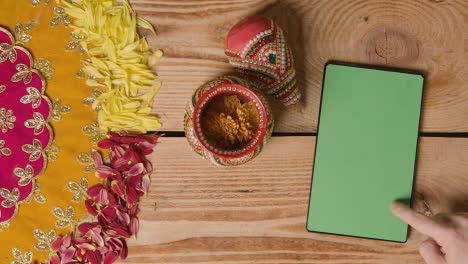 Overhead-Of-Traditional-Coconut-Pots-On-Table-Decorated-For-Celebrating-Festival-Of-Diwali-With-Digital-Tablet