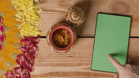 Overhead-Of-Traditional-Coconut-Pots-On-Table-Decorated-For-Celebrating-Festival-Of-Diwali-With-Digital-Tablet-1