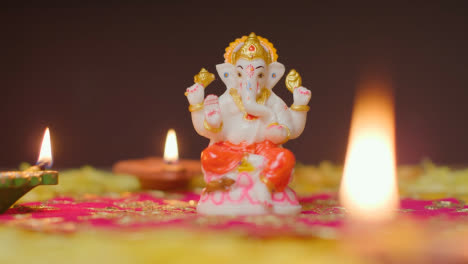 Statue-Von-Ganesh-Auf-Einem-Tisch,-Der-Mit-Diya-lampen-Dekoriert-Ist,-Um-Das-Fest-Von-Diwali-Zu-Feiern