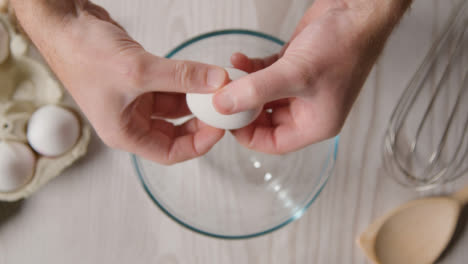 Overhead-Shot-Of-Kitchen-Utensils-On-Kitchen-Worktop-With-Person-Cracking-Egg-Into-Bowl