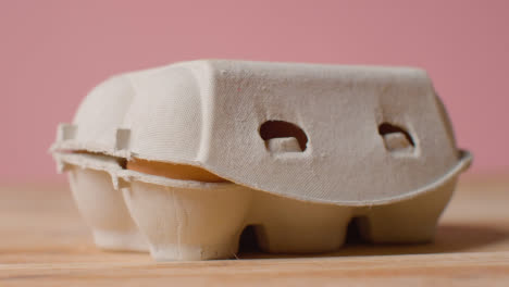 Studio-Shot-Of-Closed-Cardboard-Egg-Box-Against-Pink-Background