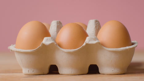 Studio-Shot-Of-Open-Cardboard-Egg-Box-Against-Pink-Background