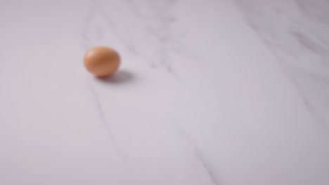 Studioaufnahme-Eines-Einzelnen-Braunen-Eies-Auf-Marmorarbeitsfläche-Hintergrund-1