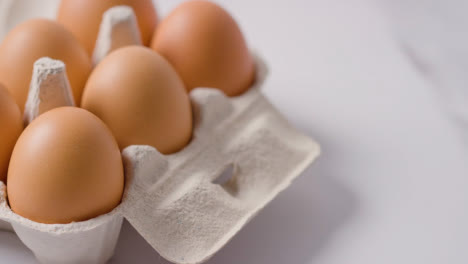 Studio-Shot-Of-Open-Cardboard-Egg-Box-Against-Marble-Work-Surface-Background-2