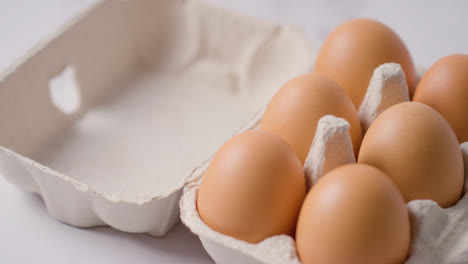 Studio-Shot-Of-Open-Cardboard-Egg-Box-Against-Marble-Work-Surface-Background-3