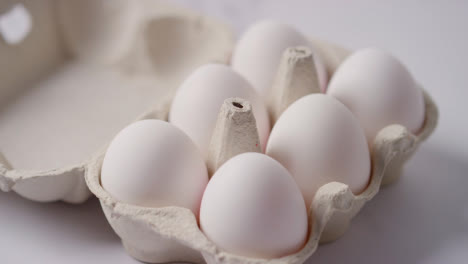 Studio-Shot-Of-Cardboard-Egg-Box-With-White-Eggs-On-Marble-Work-Surface-Background