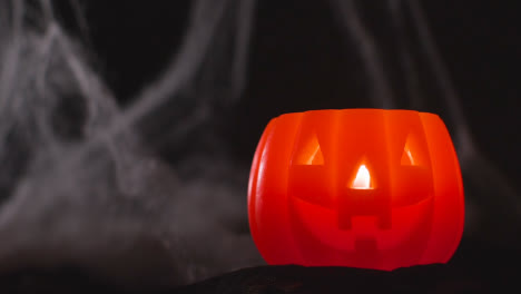 Halloween-Pumpkin-Jack-O-Lantern-With-Candle-Against-Black-Background-With-Cobwebs