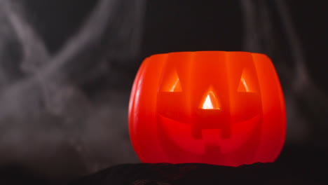 Halloween-Pumpkin-Jack-O-Lantern-With-Candle-Against-Black-Background-With-Cobwebs-1